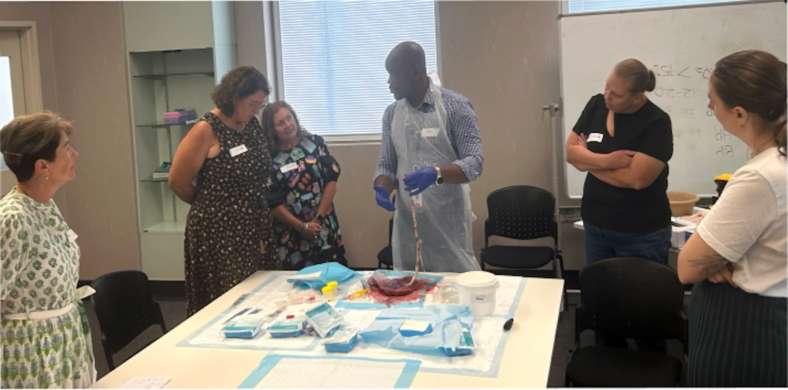 group of people around a table with medical supplies